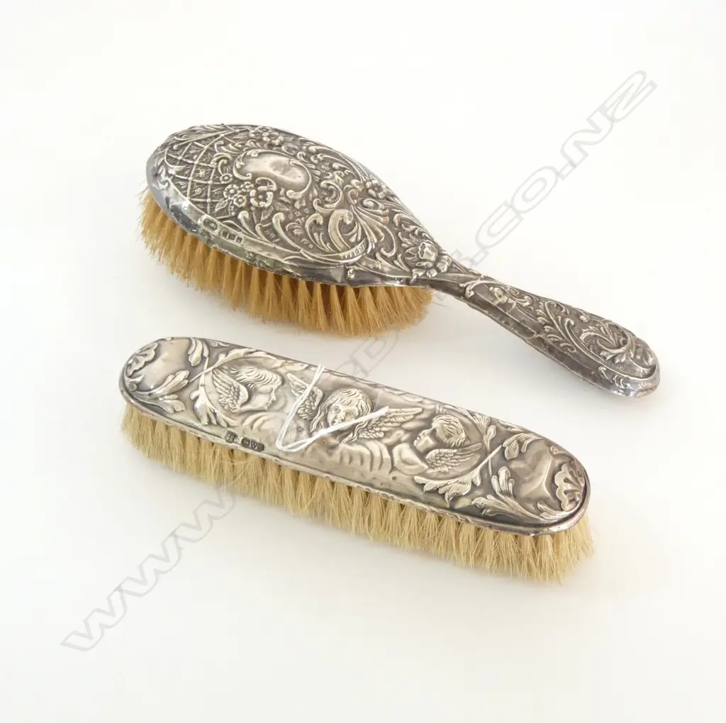TWO EMBOSSED SILVER BACKED DRESSING TABLE BRUSHES Image 1++