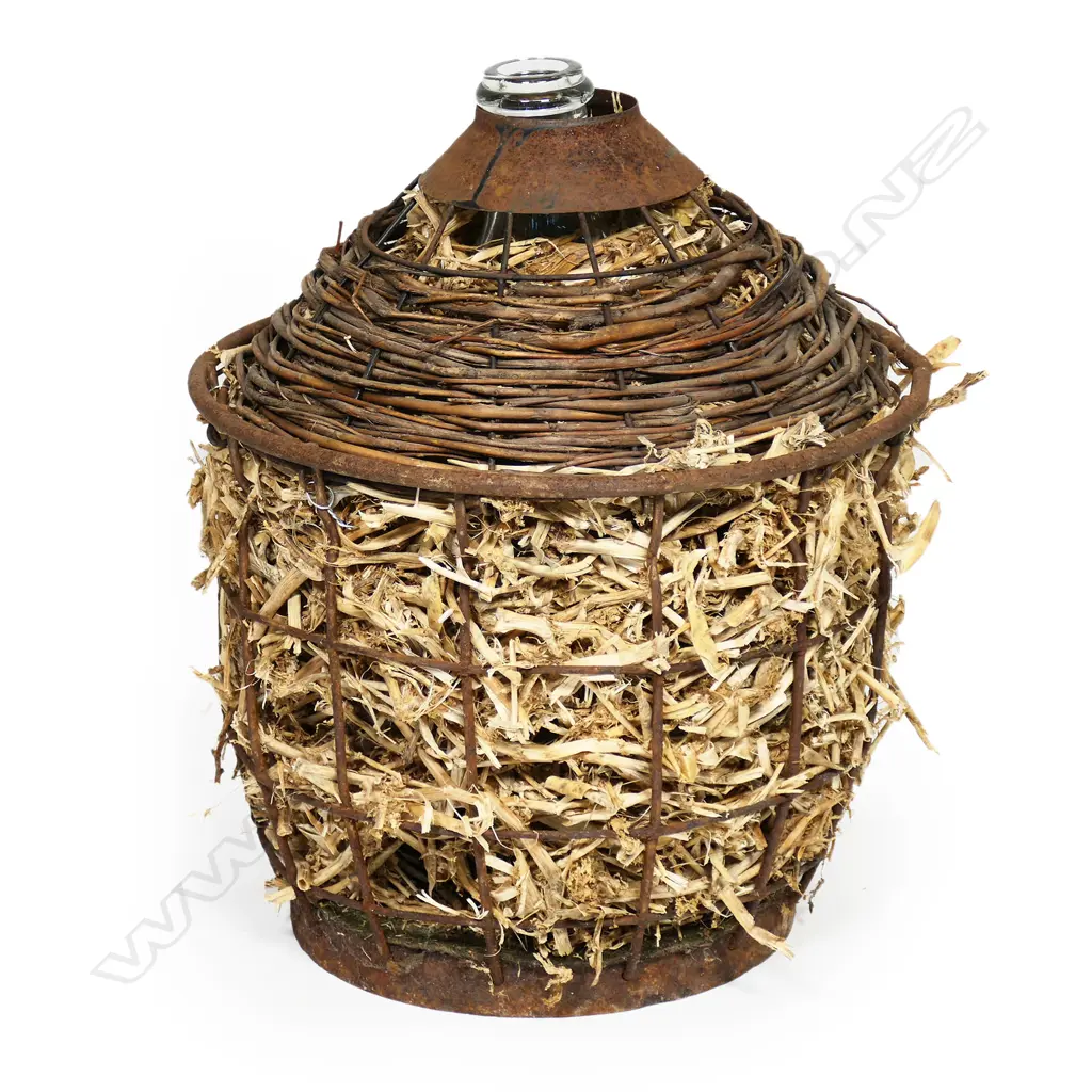 An old glass wine flagon in steel cage with moss & straw padding, Image 1++