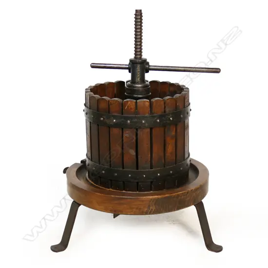 An antique French wine press with exterior slatted wood cage,
