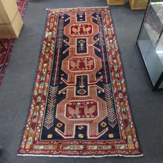 HAND KNOTTED WOOL PILE RUG three geometric medallions with repeating animal & rosette motifs, repair 3020x1360mm
