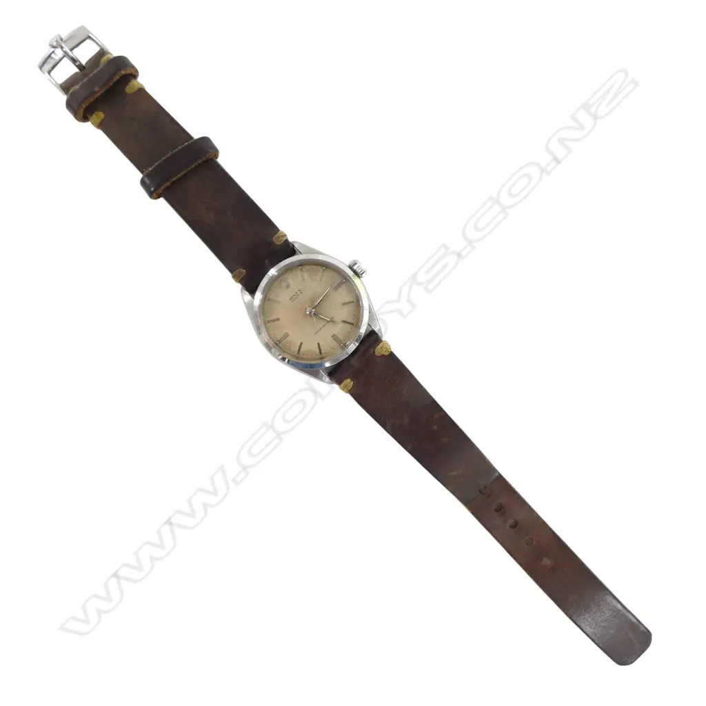A 1950's Rolex Oyster 6144 gent's wristwatch  mid size 33mm diameter stainless steel case wind down Rolex crown. baton markers, the cream toned dial named and with 'Oyster' and 'Shock-Resisting'. Working. Later old brown leather strap with Rolex branded clasp. Image 1++