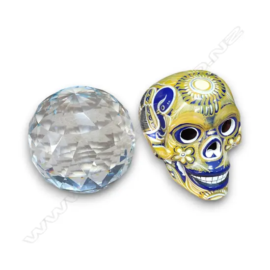 A HAND-PAINTED MEXICAN SKULL AND A LARGE FACETED GLASS PAPERWEIGHT