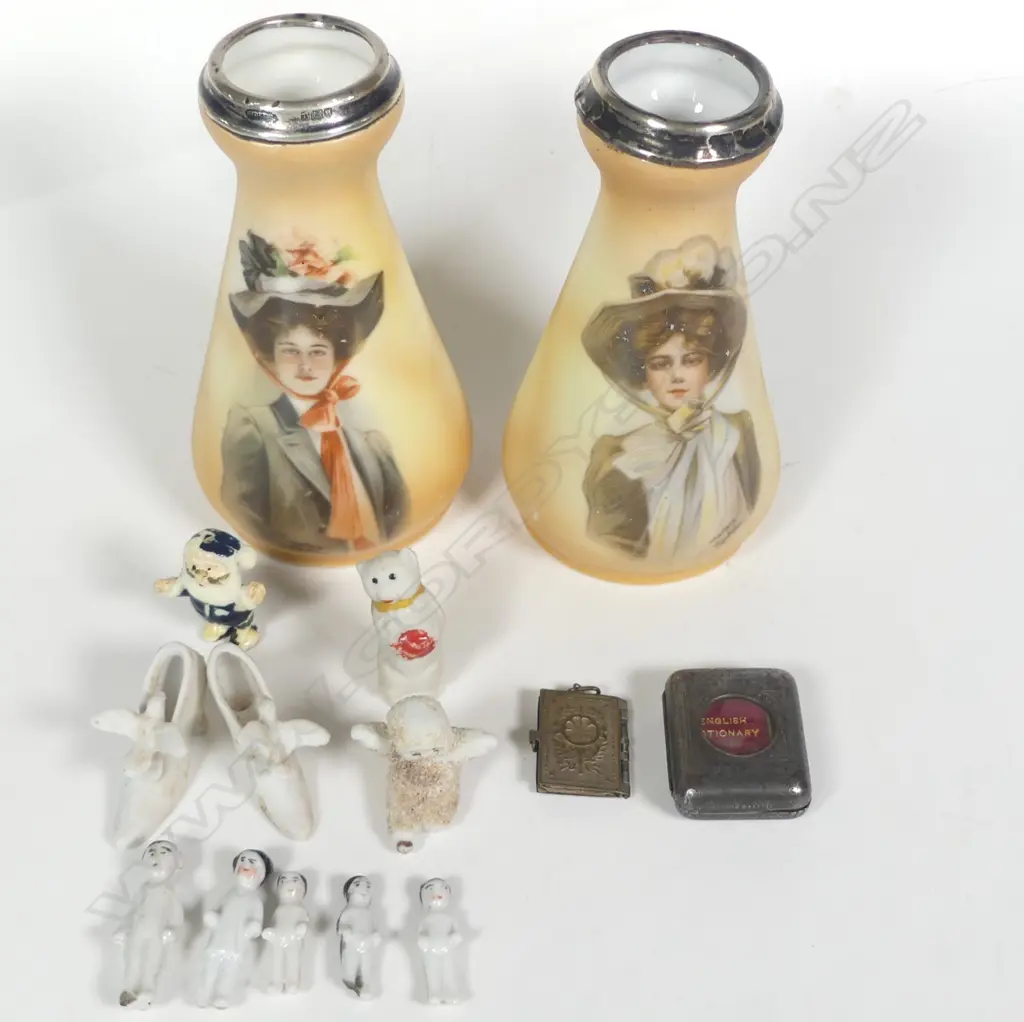 A pair of spill vases decorated with portraits of women after the illustrator Philip Boileau, silver rimmed, London 1912 by Henry Perkins & Sons. Along with a collection of mini Xmas pudding and cake dolls; a mini English Dictionary and mini Napoleonic portraits locket. Image 1++