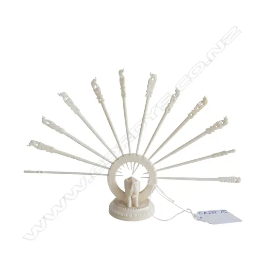 Set 12 Indian carved ivory swizzle sticks in ring stand with elephant base. H.130mm