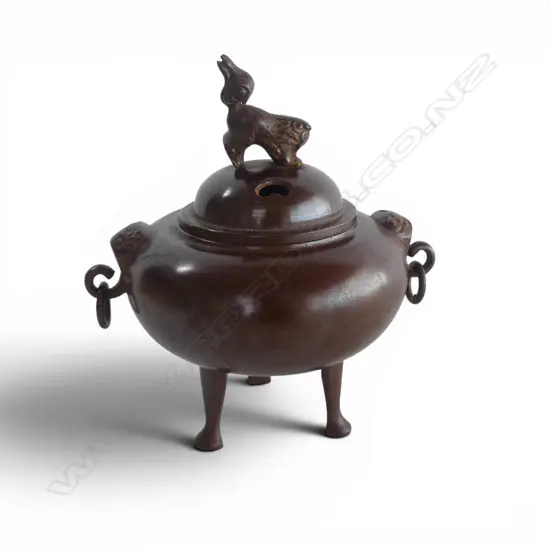 ORIENTAL BRONZE INCENSE BURNER Shishi finial & mask handles. Raised on 3 tall feet. H.140mm.