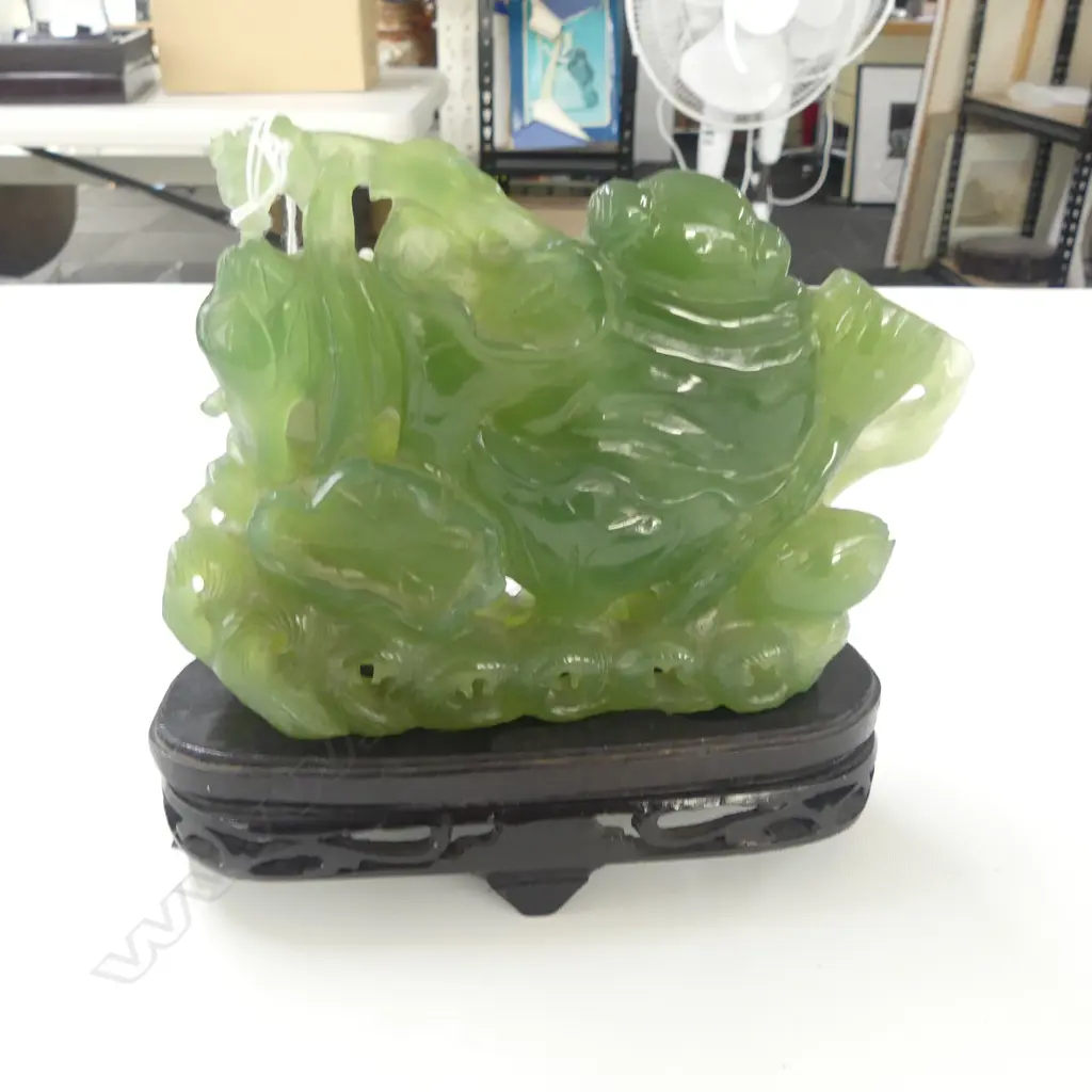 CHINESE PALE/MID GREEN CARVING OF HOTEI with lotus & goldfish. Waves to the base. Semi translucent. Tiny chip On stand.  Image 1++