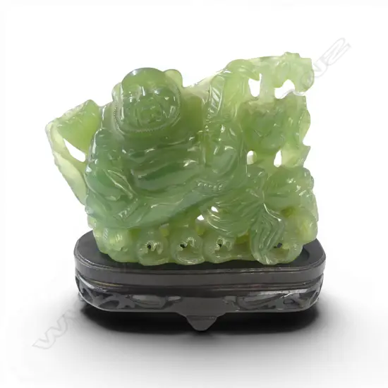 CHINESE PALE/MID GREEN CARVING OF HOTEI with lotus & goldfish. Waves to the base. Semi translucent. Tiny chip On stand. 