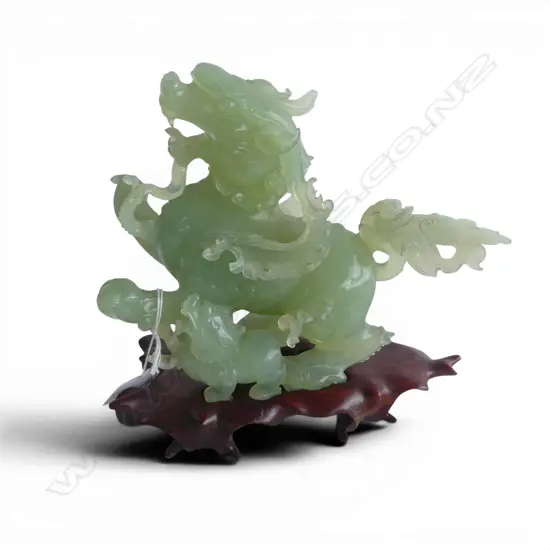 CHINESE PALE GREEN JADE CARVING OF A DRAGON with young the tail broken and restuck etc. ON WOOD STAND. H.180mm
