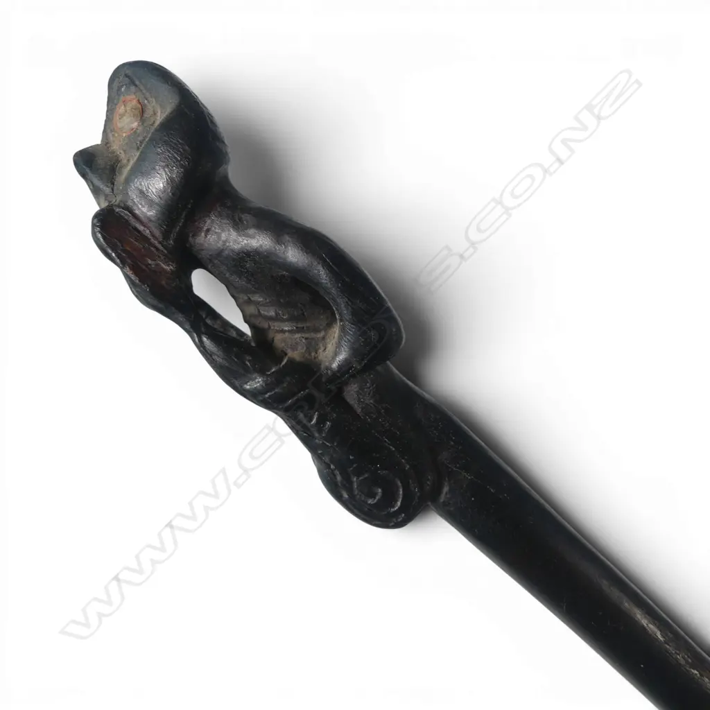 MAORI LONG STAFF (TOKOTKO) with stylised figure carved end legs raised to mouth. Probably 20thC. L.1430mm.  Image 1++