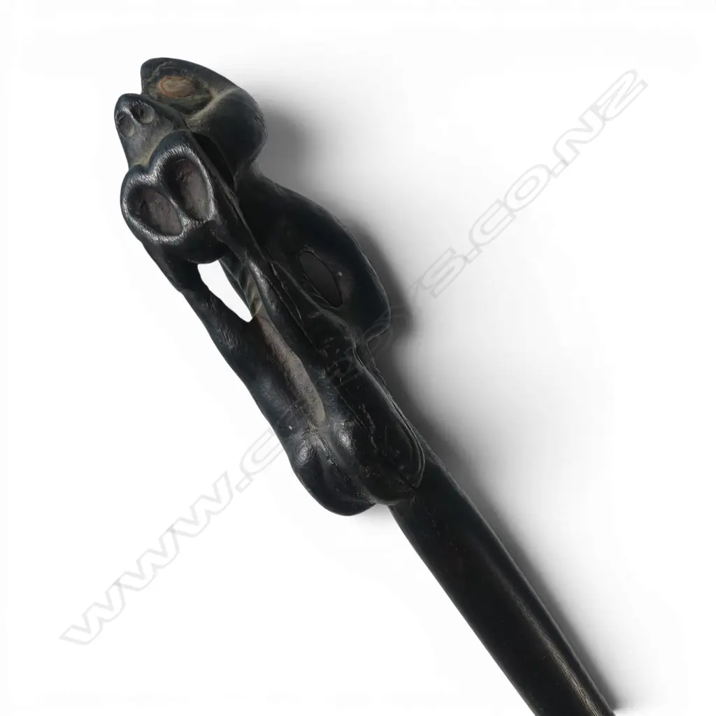 MAORI LONG STAFF (TOKOTKO) with stylised figure carved end legs raised to mouth. Probably 20thC. L.1430mm.  Image 1++