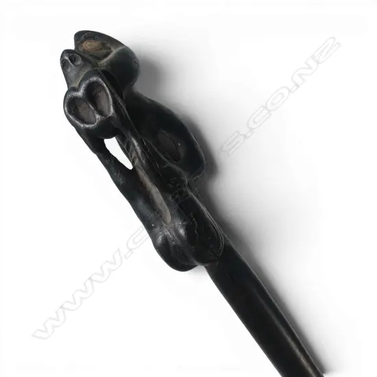 MAORI LONG STAFF (TOKOTKO) with stylised figure carved end legs raised to mouth. Probably 20thC. L.1430mm. 