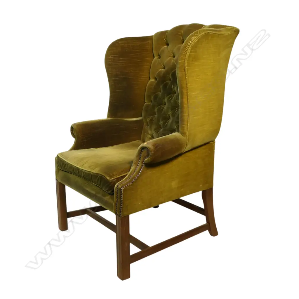 An early 20thC button and wing back chair with green velvet upholstery. Provenance: From the estate of Adrian Michael Garrett of Kerikeri. Image 1++