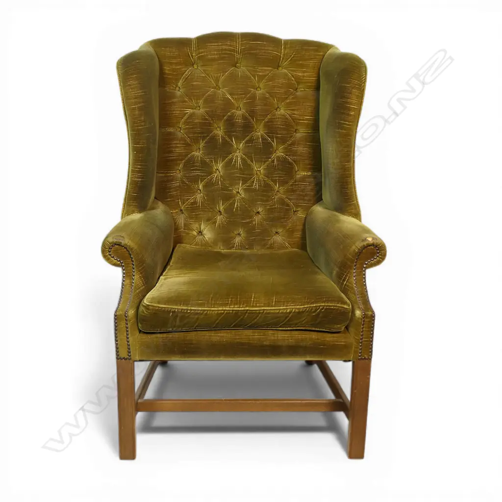 An early 20thC button and wing back chair with green velvet upholstery. Provenance: From the estate of Adrian Michael Garrett of Kerikeri. Image 1++