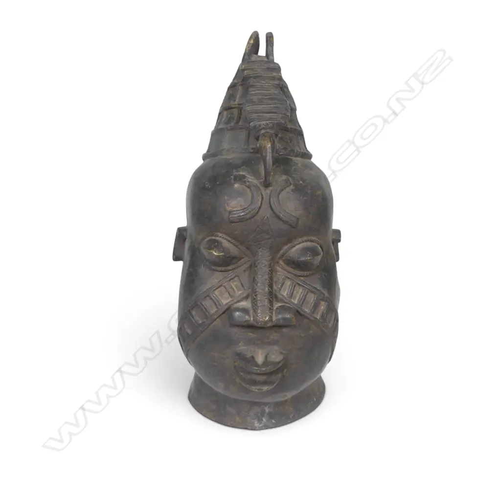 WEST AFRICAN STYLIZED DARK BRONZED METAL HEAD WITH GEOMETRIC FACIAL MARKINGS & PROMINENTS EYES,DENT ON LEFT SIDE.H.333MM Image 1++