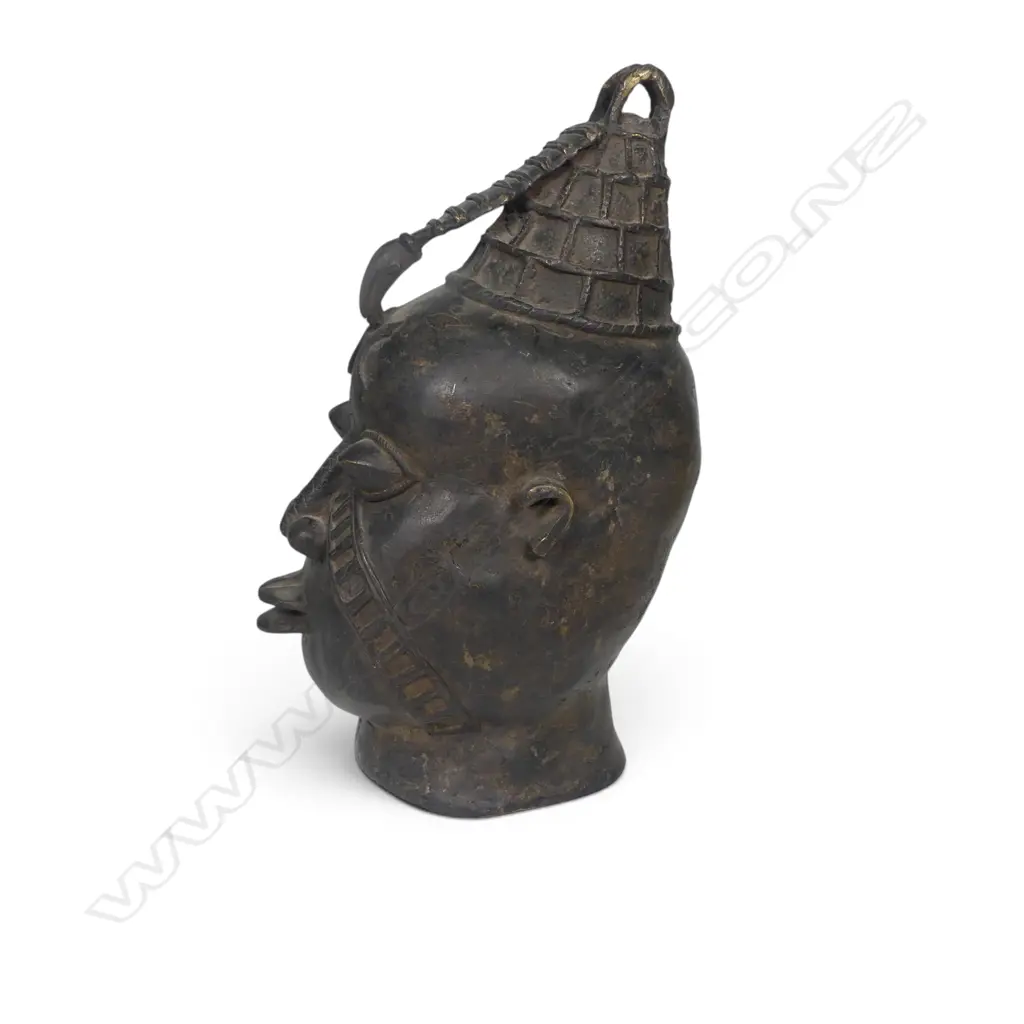 WEST AFRICAN STYLIZED DARK BRONZED METAL HEAD WITH GEOMETRIC FACIAL MARKINGS & PROMINENTS EYES,DENT ON LEFT SIDE.H.333MM Image 1++
