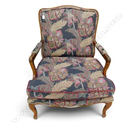 VINTAGE FRENCH-STYLE ARMCHAIR WITH A CARVED WOOD FRAME AND PATTERNED FLORAL TAPESTRY UPHOLSTERY