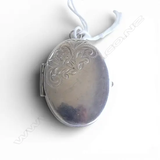 OVAL SILVER HINGED LOCKET part scroll engraved front. Engraved back. 9gms