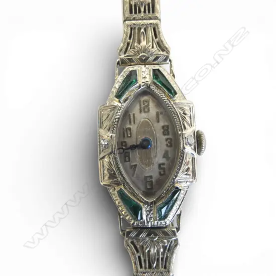 18ct WHITE GOLD DECO WATCH 2x small diamonds & green stones, going but needs o/haul. Plated strap.