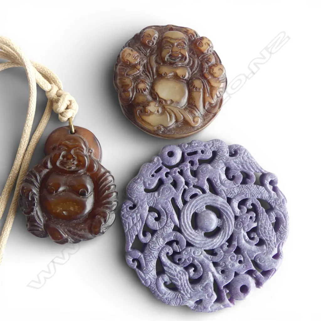 TWO CHINESE CARVED STONE BUDDHA PENDANTS AND A PURPLE CARVED STONE PENDANT WITH DRAGON DECORATION  Image 1++