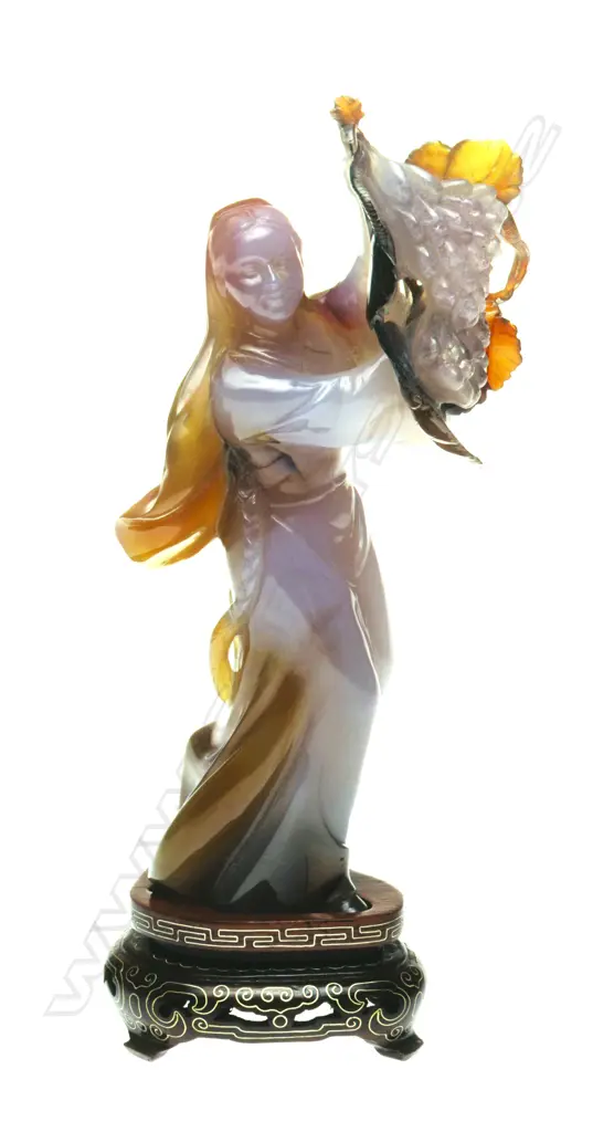 A Chinese carved chalcedony figure of a woman holding fruits Image 1++