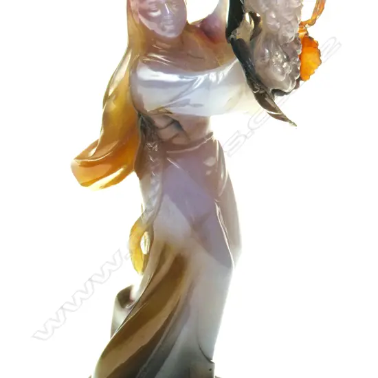 A Chinese carved chalcedony figure of a woman holding fruits