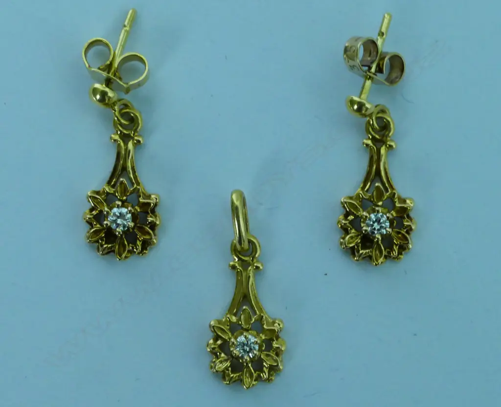 An 18ct. yellow gold and diamond pendant and earrings suite Image 1++
