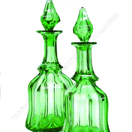 A pair of mid-Victorian faceted green glass large decanters