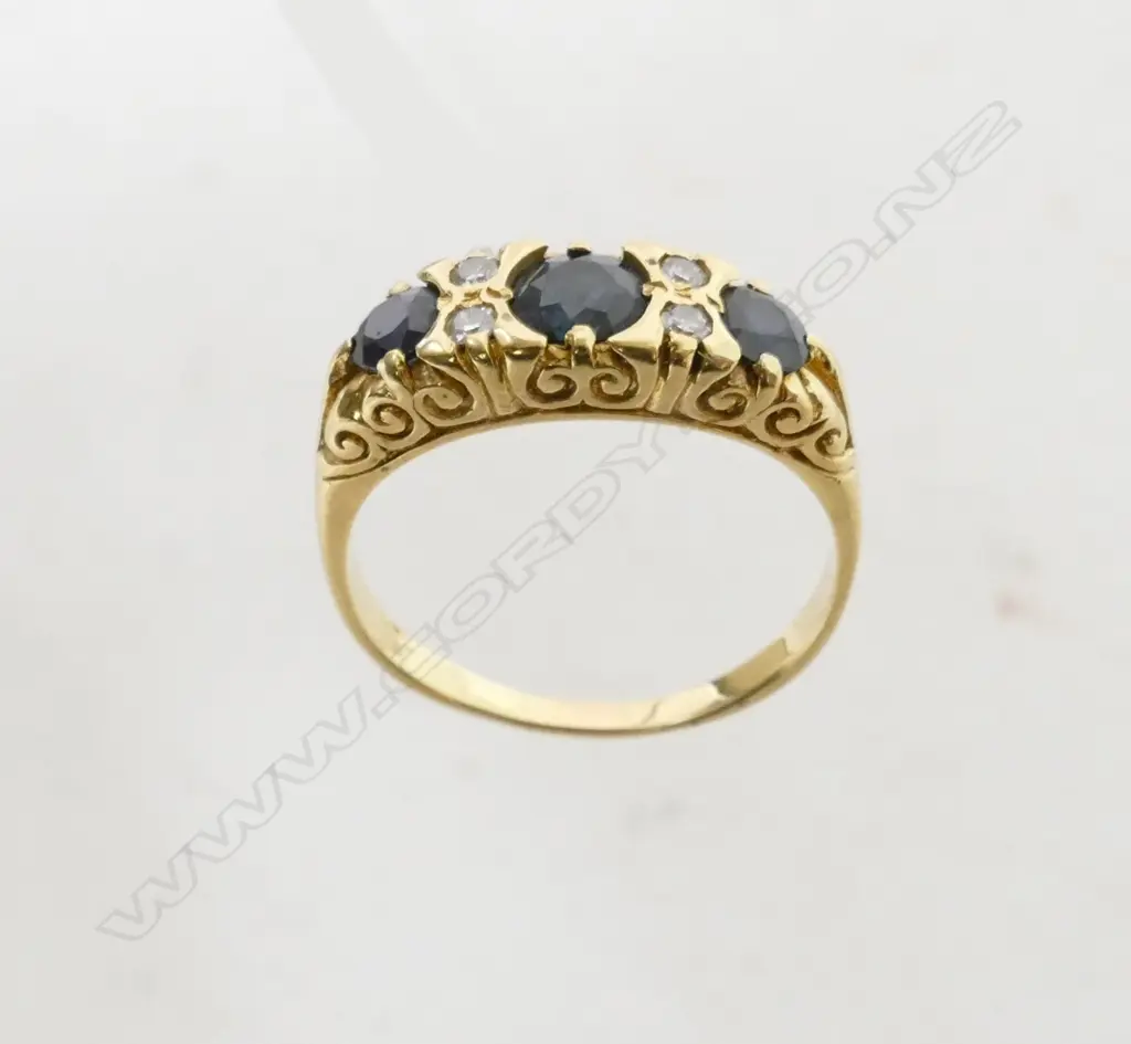 An 18ct. yellow gold sapphire and diamond bridge ring Image 1++
