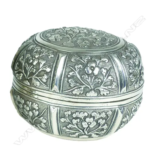 An early 20thC eastern embossed silver circular vanity box