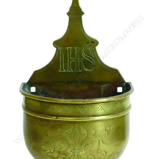 An antique brass Catholic holy water font