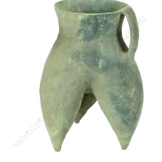 A large archaic earthenware vessel udder shaped on a triform base