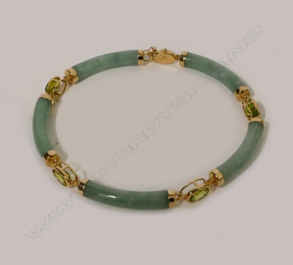 A Chinese green jade green sapphire and 14ct. yellow gold bracelet Image 1++
