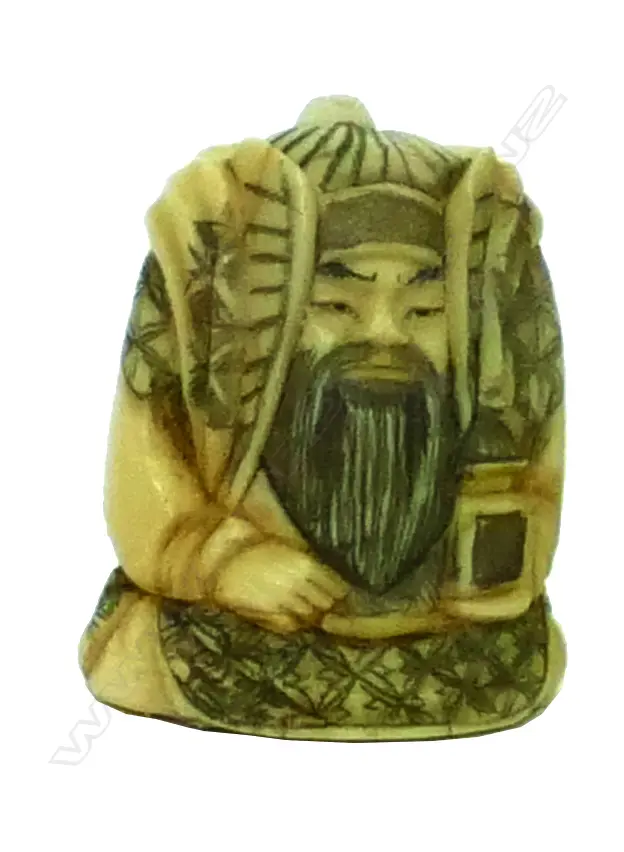 An small ivory netsuke of a robed male deity holding a fan and temple box Image 1++
