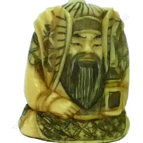 An small ivory netsuke of a robed male deity holding a fan and temple box