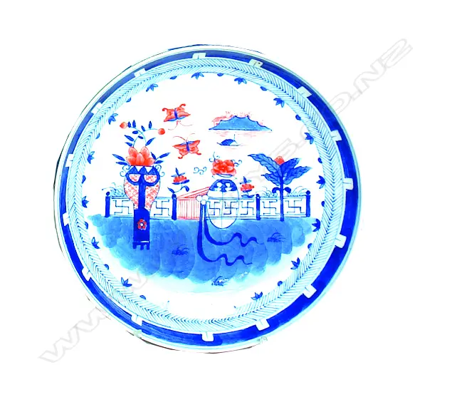 A Chinese porcelain dish painted with a wall garden in underglaze blue and iron-red within a chevron border Image 1++
