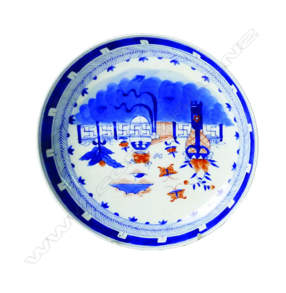 A Chinese porcelain dish painted with a wall garden in underglaze blue and iron-red within a chevron border Image 1++