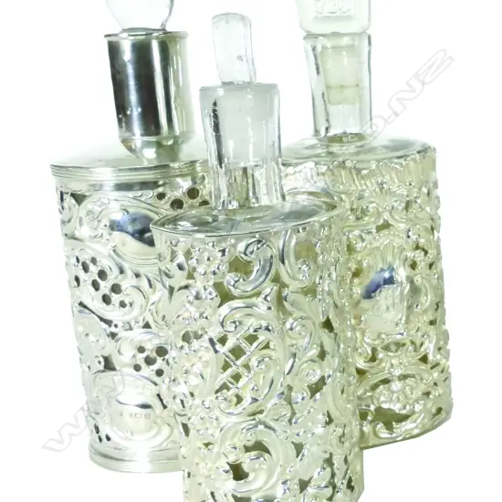 Three late Victorian silver covered glass perfume bottles