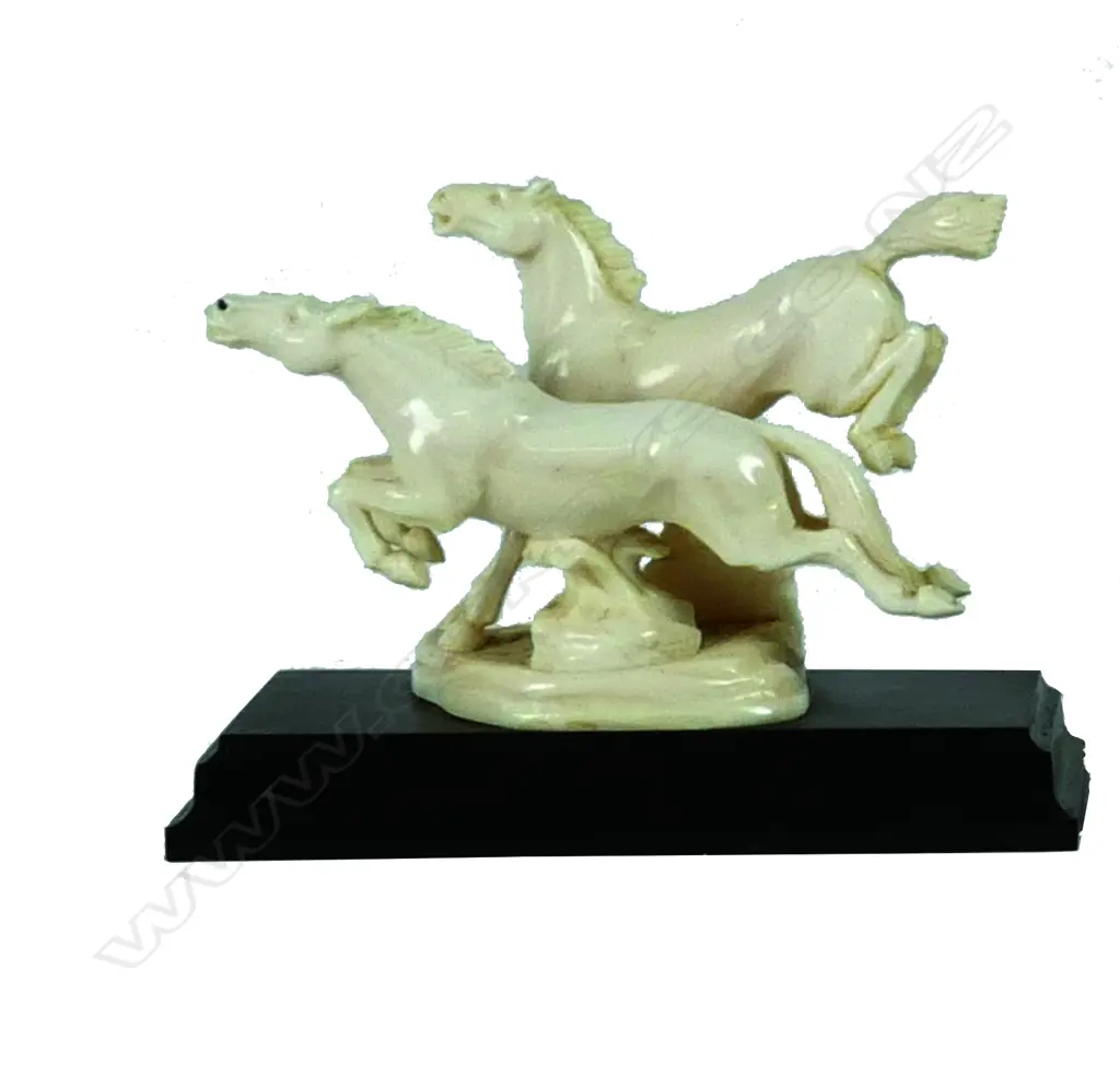 An ivory carving of two galloping horses Image 1++