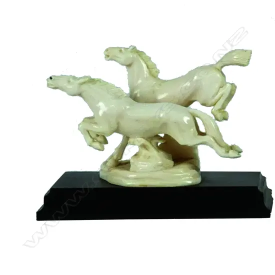 An ivory carving of two galloping horses