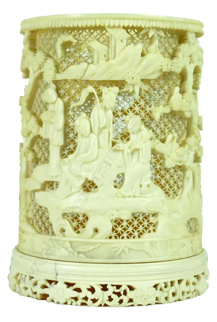 A good late 19thC Chinese finely carved ivory tusk section brush pot carved in relief with figures in a landscape of trees Image 1++