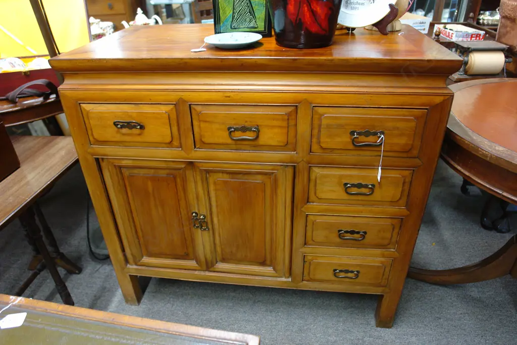 A Chinese hardwood cabinet with six small drawers and a pair of panelled cupboard doors Image 1++