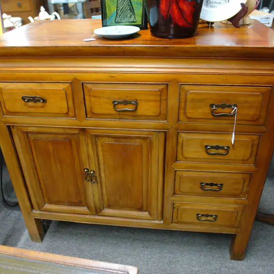 A Chinese hardwood cabinet with six small drawers and a pair of panelled cupboard doors