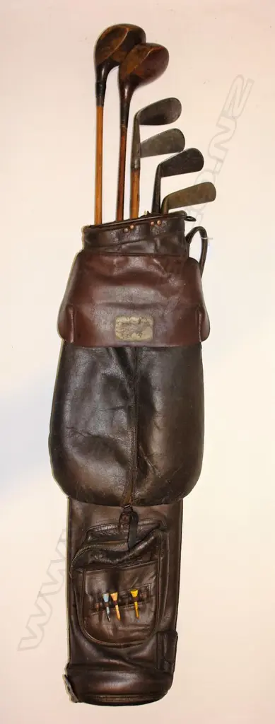 An old leather golf bag with six hickory shafted clubs Image 1++