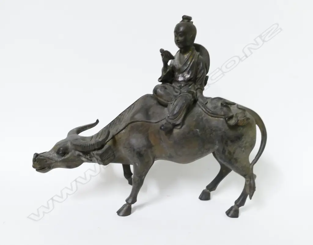 A Chinese cast metal statuette of a young boy seated on the back of a water buffalo Image 1++