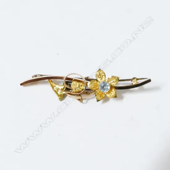 An antique 15ct. gold bar brooch set with flowers