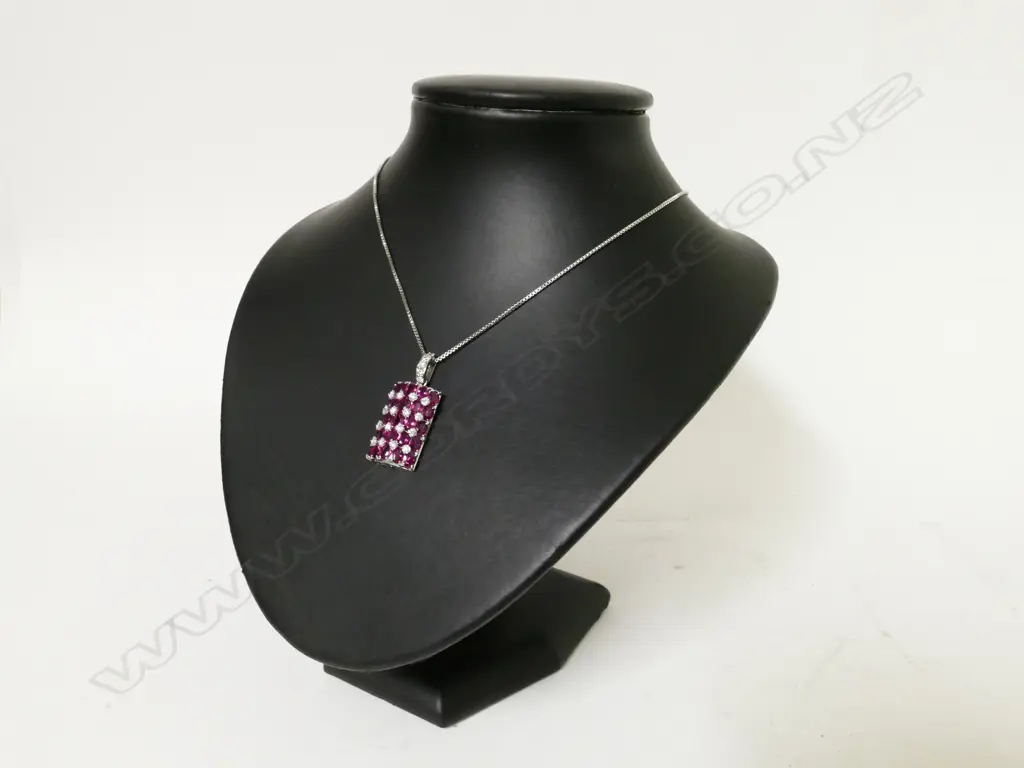 An 18ct. white gold ruby and diamond cluster pendant on chain Image 1++