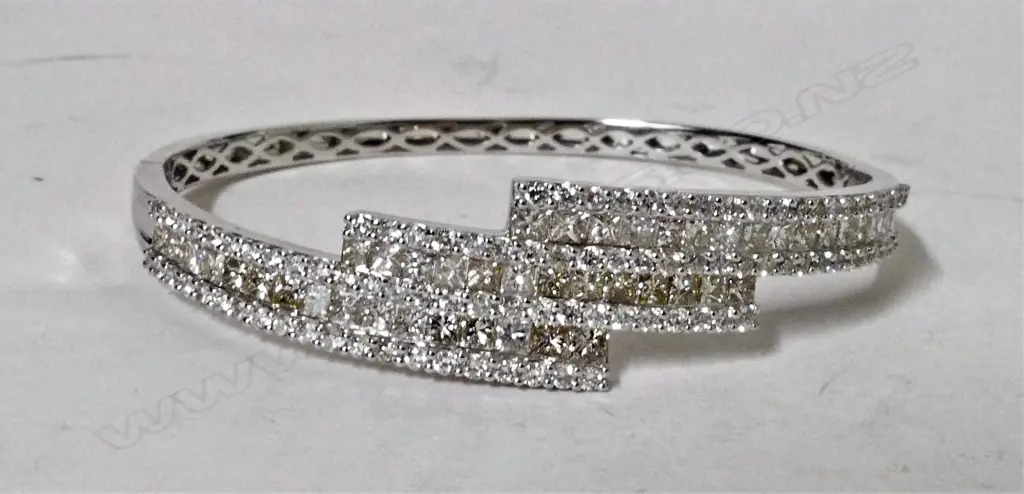 An 18ct. white gold and diamond encrusted lady's modern hinged bangle Image 1++