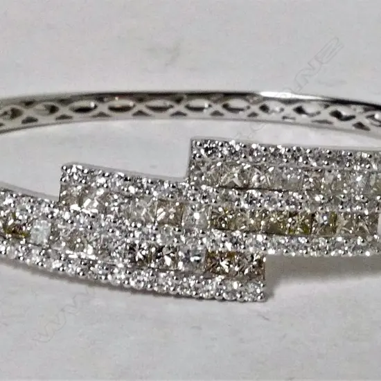 An 18ct. white gold and diamond encrusted lady's modern hinged bangle