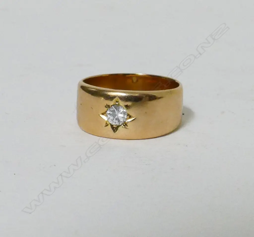 An 18ct. yellow gold band set with a brilliant cut diamond Image 1++