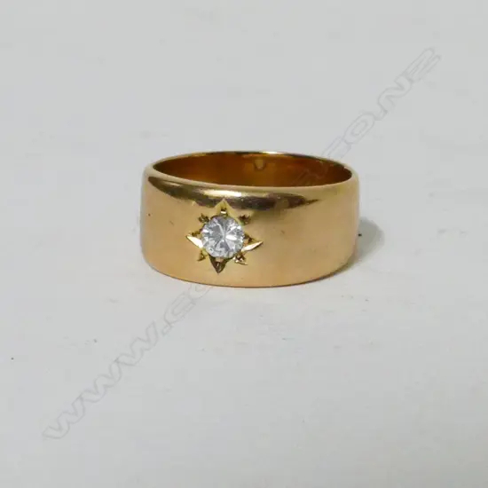 An 18ct. yellow gold band set with a brilliant cut diamond